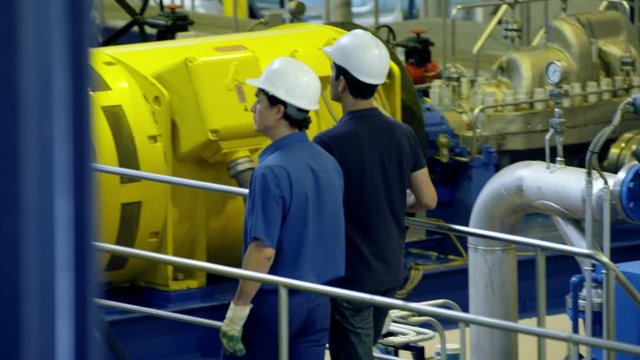 WS TS Two workers walking on gangway in water treatment plant