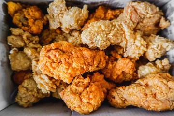 Above view of Crispy chicken drumsticks fired packed in a paper box for delivery or take home.