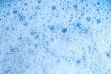 soap foam macro background.Hygiene, health and cleanliness .White soap foam with bubbles on a light blue background. Cleaning, tidiness and cleanliness concept. Bath foam.