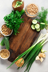 Naklejka na ściany i meble Wooden rustic cutting board with ingredients for cooking vegan food on dark background top view
