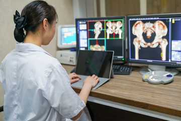 Asian Radiologist interpreting CT image with blur Hip Computed Tomography Volume Rendering...