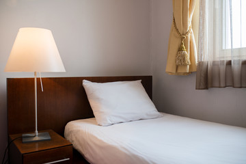 bed with pillows and duvet and the lamp is on the bedside table