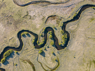 A stream meanders through a green valley, with natural twists and curves. Meandering watercourse
Top view. Aerial view of the beautiful landscape. Green field. 