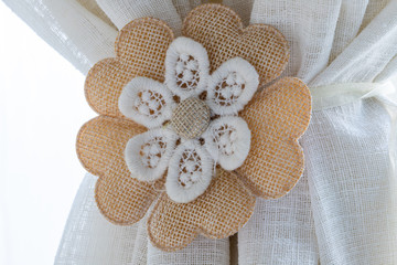 Particular objects for the home. A flower of embroidered cloth and a ribbon with two hidden magnets...