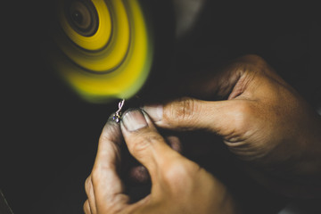 Man using his hand make a ring surface being seamless. A jewelry industry process. 