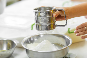 Cooking Baking. Cook sifts the flour close up