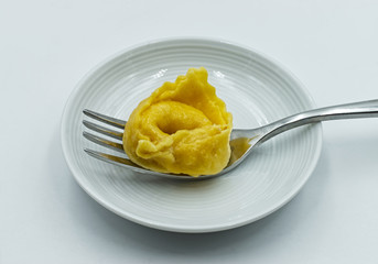 One whole fresh homemade Tortellini with butter and sage sauce. Traditional italian pasta. 