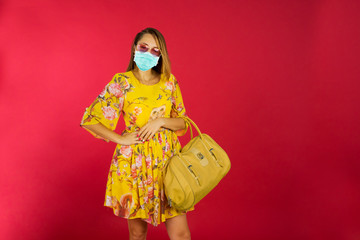 Blonde woman with face mask and handbag in studio