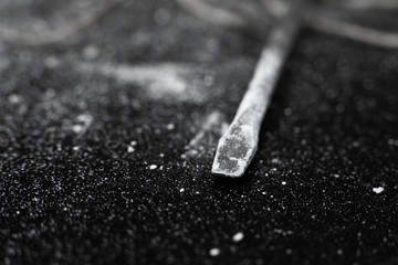 Close-up of a screwdriver sting in white dust after hollowing a wall