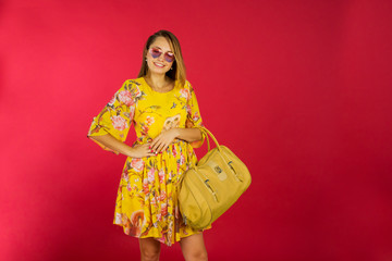 Pretty blonde woman with bag posing in studio