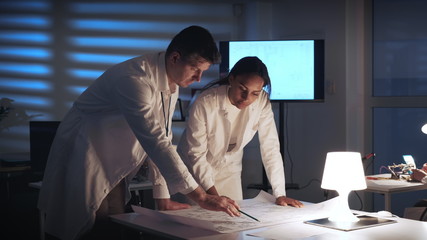 Middle close up of two engineers checking control electronics scheme in a modern lab and working on its improvement