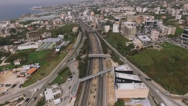 Vehicular traffic along jbeil highway near seashore and city center, Lebanon, aerial flight