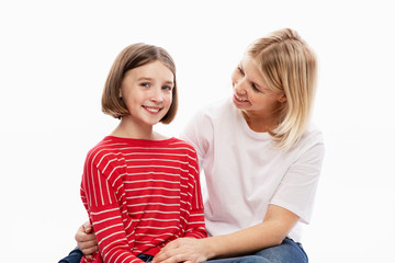 Daughter teenager and mother laugh and hug. Love and support in family relationships. White background. Space for text.