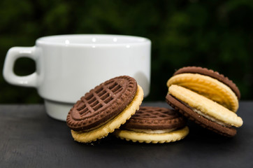 Delicious butter cream sandwich and cup of tea or coffee on the table. Close-up.