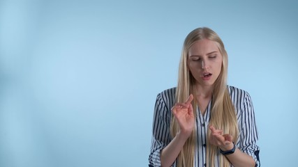 Attractive young woman counting something on fingers. There is a blue background.