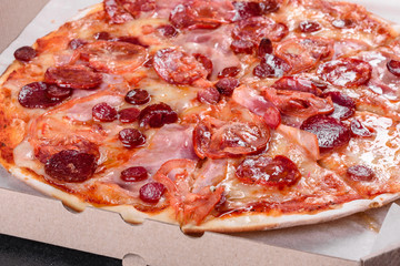Pepperoni pizza with mozzarella cheese, salami, tomatoes, pepper and spices