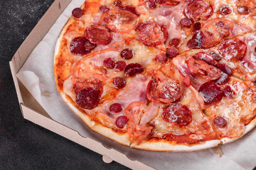 Pepperoni pizza with mozzarella cheese, salami, tomatoes, pepper and spices