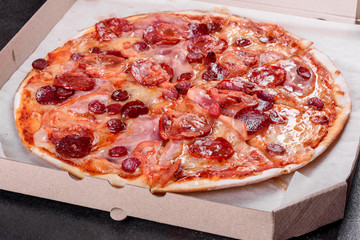Pepperoni pizza with mozzarella cheese, salami, tomatoes, pepper and spices