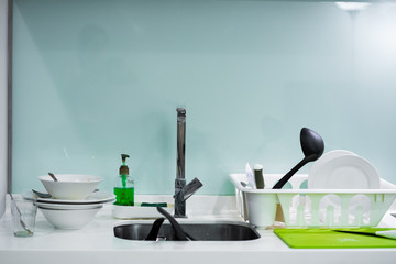 A mountain of dirty dishes in the kitchen sink. Mess in the house