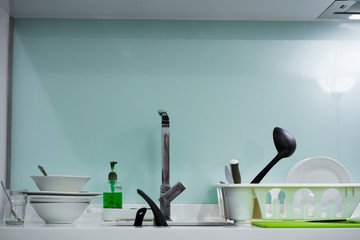 A mountain of dirty dishes in the kitchen sink. Mess in the house