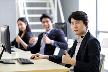 Asia Group of call center workers or Confident business team with headset in office.