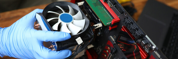 Male hand in blue protective gloves repair and upgrade desktop pc closeup background. Fast help...