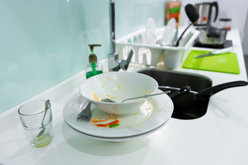 A mountain of dirty dishes in the kitchen sink. Mess in the house