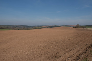 Fototapeta na wymiar Raked and Rolled Field Ready for the Planting of Spring Crops on a Farm in Rural Devon, England, UK