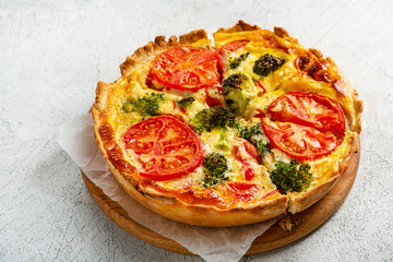 Quiche lorraine with broccoli and cheese on  cutting board, food close up