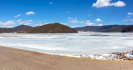 Fototapeta na wymiar Potatso National Park or Pudacuo National Park during winter with mountain and frozen lake scenery with snow covered ground