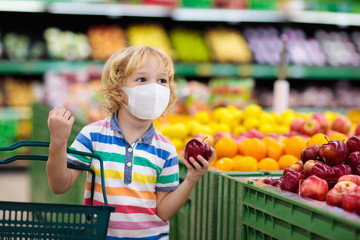 Child in supermarket. Kid grocery shopping.