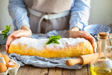 Apple strudel from the oven. Mint strudel.The cook makes the cake.Housewife is preparing an apple pie.Mom prepares dessert.Vienna apple strudel. Sliced ​​piece of cake.Mistress cuts homemade dessert 