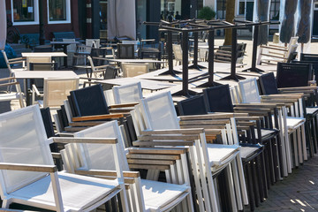 Empty terrace with stacks of chairs and tables due to the restaurant closure during the coronavirus outbreak in The Netherlands.