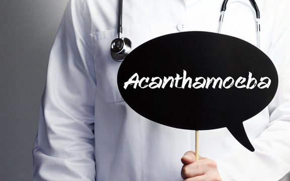 Acanthamoeba. Doctor in smock holds up speech bubble. The term Acanthamoeba is in the sign. Symbol of illness, health, medicine