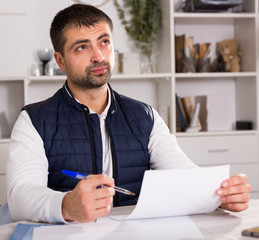 Young male struggling to pay utility bills and rent