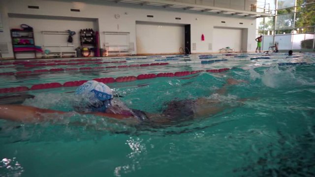 A young woman swimming crawl style in an olympic pool