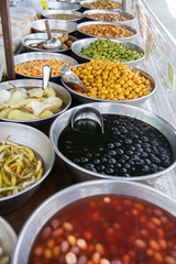 Large selection of different pickled and salted olives and other vegetables on the outdoor sesonal market in Spain