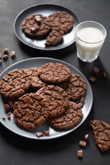 traditional freshly baked cookies with chocolate, glass of milk, cone jam  on a gray background close-up