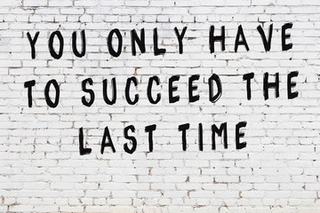 Black painted inscription of smart quote on white brick wall