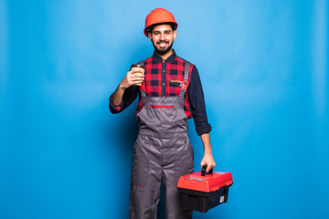 Portrait of indian man holding a red tool box isolated on blue background
