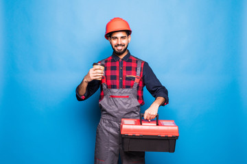 Portrait of indian man holding a red tool box isolated on blue background