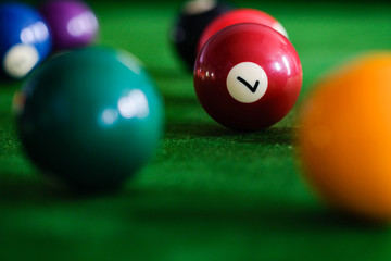 Man's hand and Cue arm playing snooker game or preparing aiming to shoot pool balls on a green...