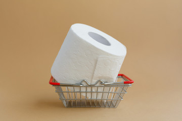 roll of white toilet paper on a brown background and a grocery basket