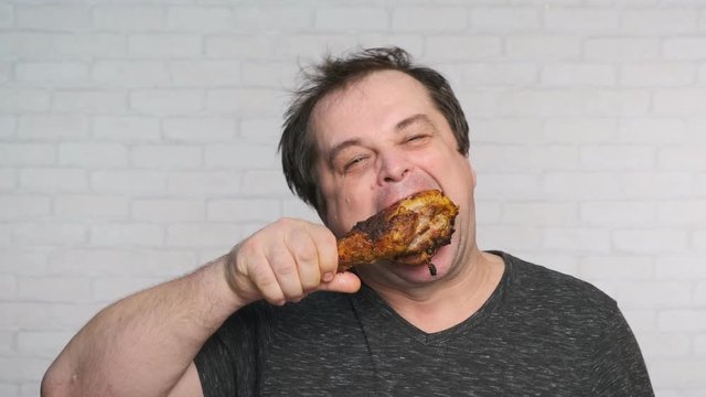man eating fried turkey leg close-up.