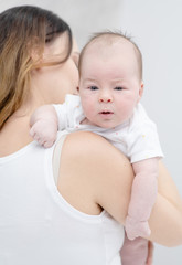 Mother holding her newborn baby daughter after birth on arms.  Concept of love and family.