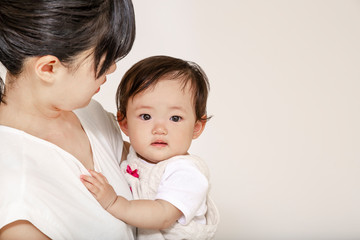 お母さんに抱かれカメラ目線の赤ちゃん