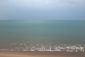 Sea before rain. Beautiful nature background of aquamarine colors water and cloudy sky during a thunderstorm. Summer beach without people