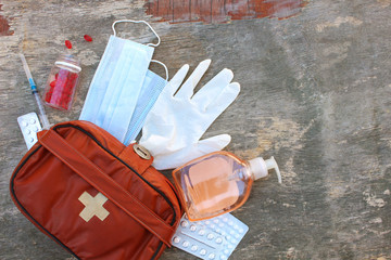 First aid kit on old wooden background. Concept of protect yourself from COVID-2019. Top view.