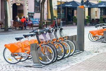 Sustainable transport. Row of bikes parked for hire in the old town, city bikes rent parking,...