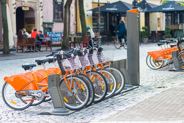 Sustainable transport. Row of bikes parked for hire in the old town, city bikes rent parking,...